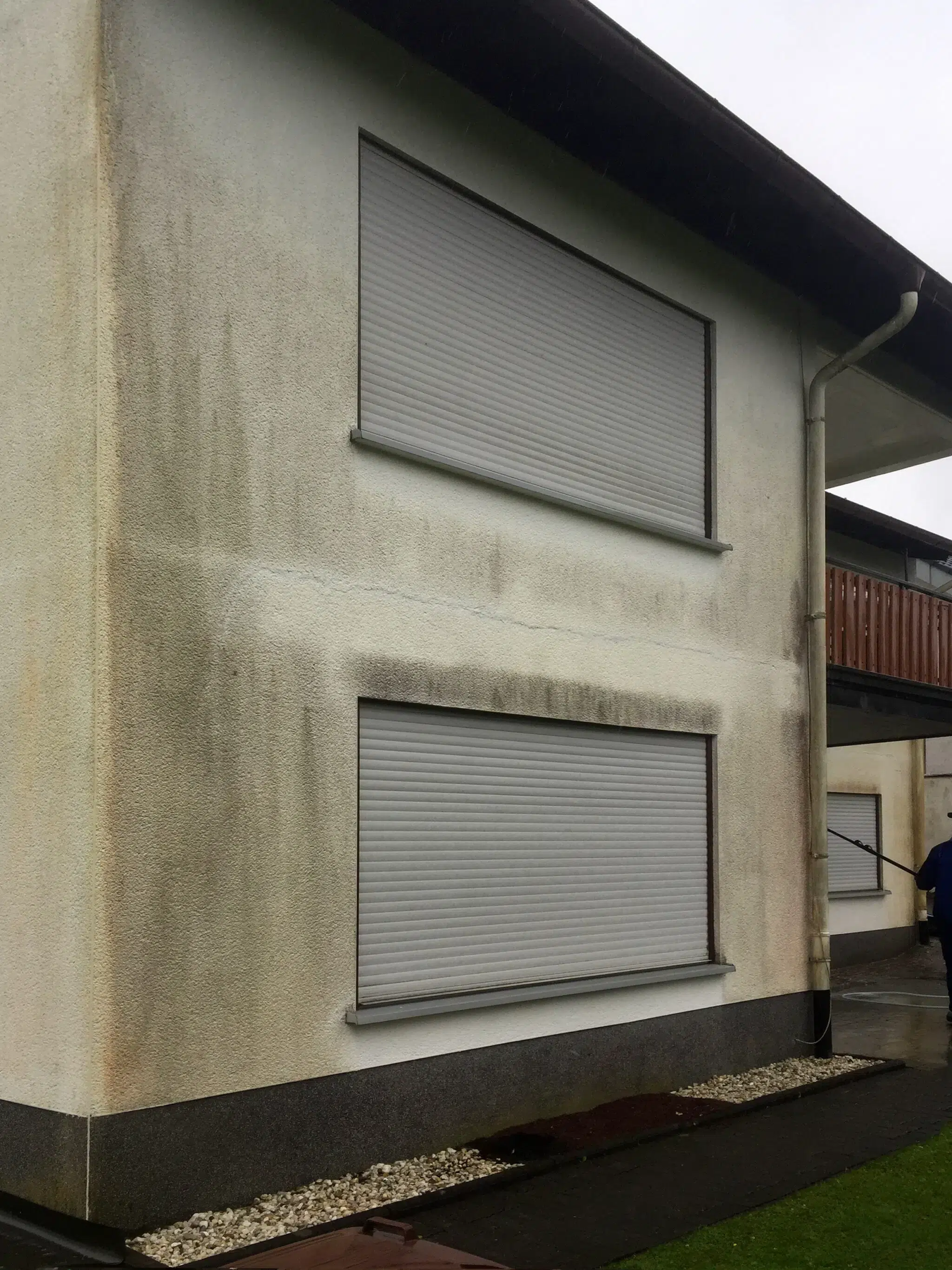 Dunkle Streifen und Flecken auf einer Fassade
